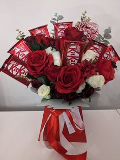 a vase filled with roses and chocolate bars