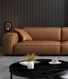 a brown leather couch sitting next to a black table