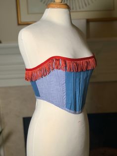 Over-bust strapless corset with flexible boning and white lacing in back.  Made entirely of scrap fabrics. Mismatched denim with red western fringe. Sizing is pretty flexible because of lace-up closure. Just choose the size that you feel is closest and I will make the corset specifically to your measurements. Message me if you have questions!  Mannequin's measurements - Waist: 27" Bust: 37" Generally here are the sizes, but I will modify it to fit you based on your bust and waist measurements: Small fits a US 4-8  Medium fits a US size 6-12 Large fits a US 12-16 XL fits a US 16-20 Please send me your bust and waist measurements when ordering so I can make sure it will fit perfectly! Summer Festival Underbust Corset, Summer Festival Corset With Boned Bodice, Fitted Sleeveless Tube Top For Festivals, Blue Denim Strapless Corset, Vintage Summer Festival Corset, Bohemian Fitted Strapless Tube Top, Fitted Bohemian Tube Top For Festivals, Fitted Strapless Tube Top For Festival, Red Overbust Corset For Festival