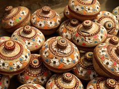 many decorated pots are sitting together on the table