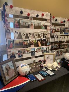 a table topped with pictures and photos next to a wall covered in paper bunting