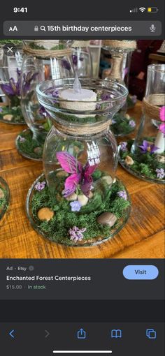 a table topped with lots of glass vases filled with flowers and rocks on top of it