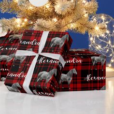 two wrapped presents under a christmas tree with the word merry and horse on them, both wrapped in plaid paper