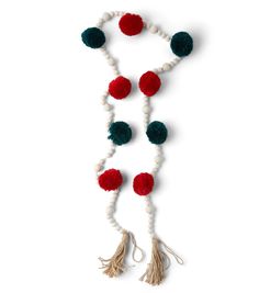 a white and red tasselled necklace with pom - poms on it