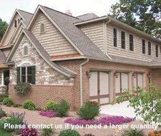 a large brick house with lots of flowers in the front yard