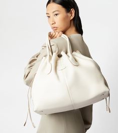 The iconic Tod's Di Bag style reinterpreted in a refined drawstring closed version. Crafted in soft full grain leather, with the distinctive Tod's logo stamped on the front, this versatile bag features two tubular handles and an adjustable and removable shoulder strap. Completed by an internal pouch, it accompanies with class and femininity your everyday outfit. Drawstring Tote Bag, Oversize Fashion, Essential Bag, Everyday Outfit, Gift Boutique, Bag Style, Perfect Bag, Womens Tote