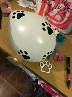 a white balloon with black paw prints on it sitting on top of a wooden table