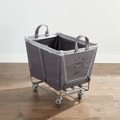 a grey shopping cart with two handles on the top and one holding a black bag