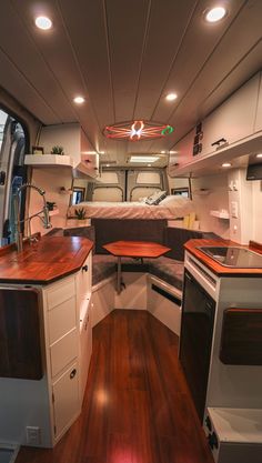 the interior of a camper with wood floors and white cabinets, including an oven