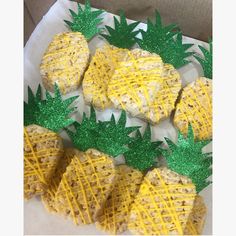 pineapple rice krispy treats are arranged on a paper towel with green glitters