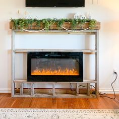 an electric fireplace in a living room with a tv above it and plants on the mantle