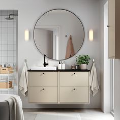 a bathroom with a large round mirror above the sink