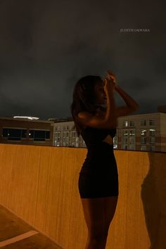 a woman standing on top of a roof at night