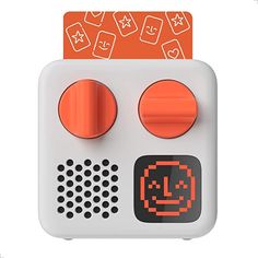 an orange and white game controller with two buttons on top of each button, which has a smiley face drawn on it