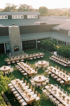 an aerial view of tables and chairs set up in front of a building with trees