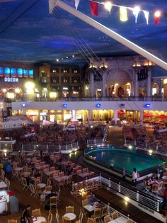 an indoor dining area with tables, chairs and umbrellas in the middle of it