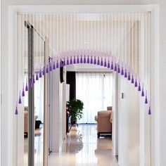 an arch in the hallway is decorated with purple fringes