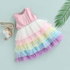 This charming, rainbow layered dress will make your little princess look just as glamorous as you! It features a multicolor, layered skirt, a tulle bodice and a bow at the back. Made for special occasions, this versatile dress can also be worn casually. Influencer @helena.modenezi Material: Cotton, polyester Multicolor Sleeveless Tutu Dress For Spring, Cute Pink Tiered Skirt Dress, Spring Cute Princess Dress With Tulle Skirt, Cute Spring Princess Dress With Tulle Skirt, Multicolor Sleeveless Spring Tutu Dress, Multicolor Sleeveless Twirl Dress With Ruffles, Playful Summer Tutu Dress With Tulle Skirt, Summer Tiered Tutu Dress With Ruffles, Summer Tiered Tutu Dress With Tulle Skirt