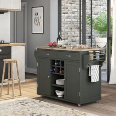 a kitchen island with wine bottles and plates on it in front of a brick wall