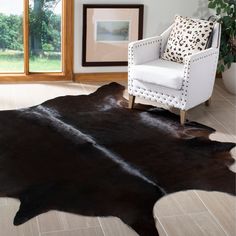 a large black and white cowhide rug in a living room