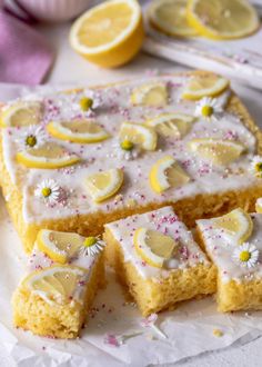 lemon cake with white icing and sprinkles cut into squares on a plate