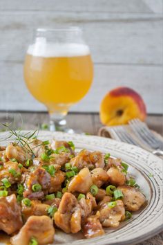 a white plate topped with meat and veggies next to a glass of beer