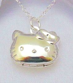 This sterling silver plated locket features Hello Kitty in the shape of a cartoon character and measures 3/4" x 7/8". It opens and closes with a snap-release lock, and small items can be stored inside. The necklace includes either a link chain or lobster clasp snake chain. A free silver color gift box will be provided upon request. Surprise your daughter with this adorable sterling silver plated locket pendant featuring her favorite cartoon character, Hello Kitty! The locket measures 3/4" x 7/8" Kawaii Hello Kitty Silver Jewelry, Kawaii Silver Hello Kitty Jewelry, Silver Hello Kitty Kawaii Jewelry, Silver Kawaii Jewelry With Cat Design, Hello Kitty Cat, A Cartoon Character, Gifts For Daughter, Hello Kitty Jewelry, Silver Link Chain