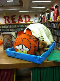 a stuffed animal laying on top of a book case in a library filled with books