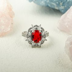 a close up of a ring with a red stone in the center surrounded by crystals