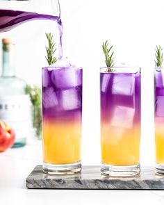 three glasses filled with purple and yellow liquid