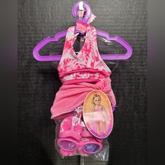 the barbie doll is wrapped in a pink towel and has sunglasses on it's head