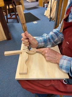 an older man is working on a piece of wood