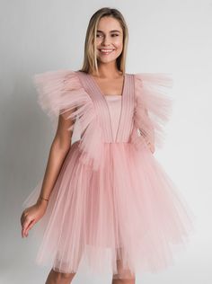 Tulle Dress for Women with Tutu Skirt and Tulle Filling on Shoulders. Perfect choice as a Bridesmaid Dress or in White as Wedding Dress. This Unique dress really puts on a show with tulle filling silhouette. Short Tulle Dress is enough to put anyone in the mood for partying. A.P.Line is more than just a custom-made clothing brand; we are the style experts, the design gurus and the professional seamstresses readily at your service. Express your individuality with a bit of modern luxury that has b Princess Style Evening Dress With Tulle Skirt, Sleeveless Fairy Dress With Ruffles For Wedding, Bridesmaid Tulle Evening Dress With Ruffles, Princess Style Tulle Dress For Prom Season, Wedding Tutu Dress With Sweetheart Neckline, Tulle Fairy Dress For Wedding, Elegant Pink Tulle Fairy Dress, Tulle Bridesmaid Ball Gown, Pink Tulle Bridesmaid Evening Dress