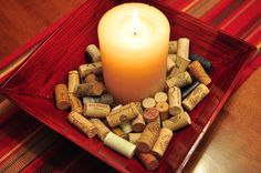 a lit candle is surrounded by wine corks