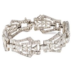 Art Deco platinum and diamond bracelet, designed as a series of openwork geometric links set throughout with various-cut diamonds weighing approximately 9.00 carats, GH color VS clarity. The gross weight is 37.2 grams, length 7 ⅛ inches, width ¾ inch. Art Deco Platinum Diamond Bracelet, Art Deco White Gold Diamond Bracelet, Art Deco White Gold Jubilee Diamond Bracelet, Art Deco Diamond Bracelet In White Gold, Art Deco White Gold Diamond Bracelet With Brilliant Cut, Art Deco White Gold Diamond Bracelets, Art Deco White Gold Bracelets With Brilliant Cut Diamonds, Art Deco Diamond Bracelet With Accents, Art Deco Diamond Jubilee Bracelet