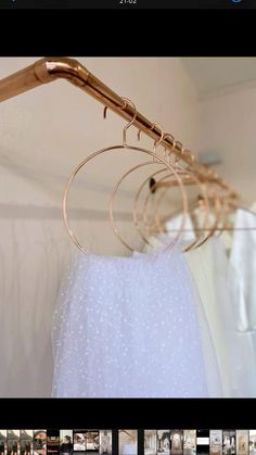 three pairs of gold hoop earrings hanging from a clothes rack with white tulle skirt