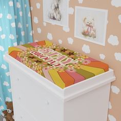 a baby crib in the corner of a room with teddy bears on the wall