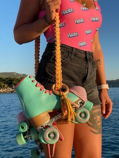 a woman in pink shirt holding up skateboard with wheels and chains attached to it