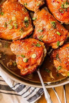 chicken thighs with sesame seeds and seasoning in a skillet on a wooden table