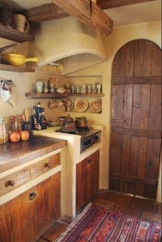 an old fashioned kitchen with wooden cabinets and antique rugs on the floor in front of it