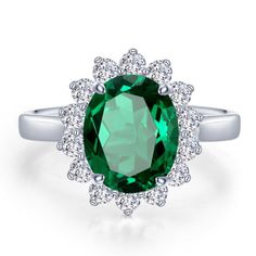 an oval green gemstone surrounded by white diamond halos on a silver band ring