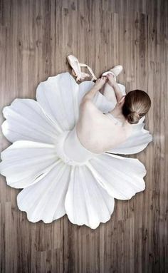 a woman in a white dress laying on the floor