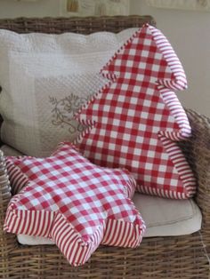 two red and white pillows sitting on top of a wicker chair next to each other