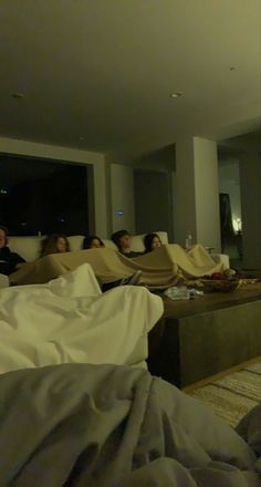 a group of people sitting on couches in a living room next to each other