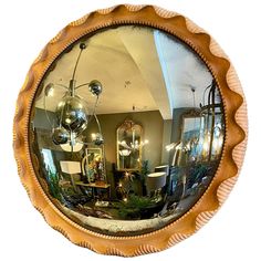 a mirror that is on the wall in front of a table with lamps and pictures