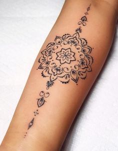 a woman's arm with a tattoo design on the left side of her arm