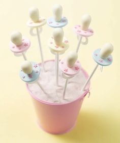 there are many small marshmallows in a pink cup on the yellow table