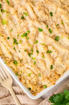 a casserole dish filled with mashed potatoes and garnished with parsley