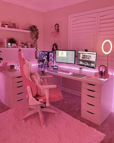 a pink room with two computer desks and a chair in front of the window