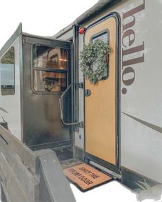 an open door to a trailer that has a wreath on the front and side of it